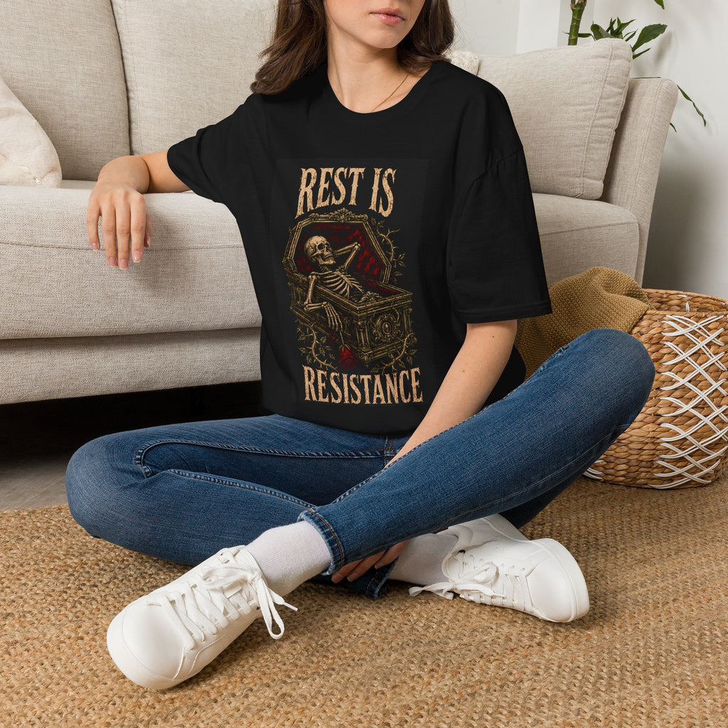 Model wearing a black t-shirt with Rest Is Resistance text with a resting skeleton, front view.