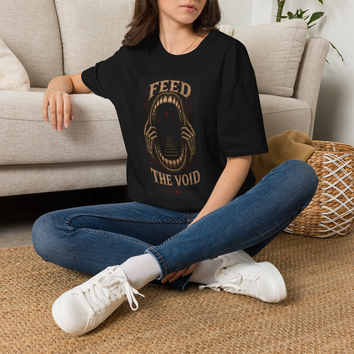 Model wearing a black t-shirt with Feed the Void text around a dark open mouth, front view.
